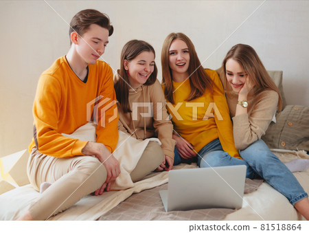 Teenage friends watching funny content on laptop and laughing 81518864