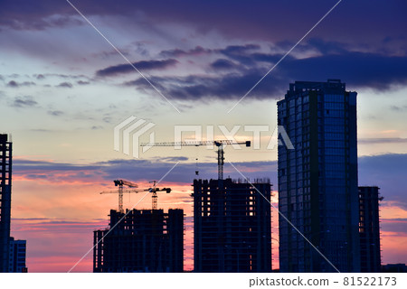 Silhouettes of tower cranes on awesome sunset background. 81522173