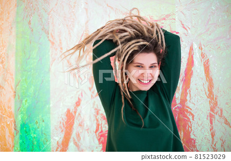 Happy woman shaking dreadlocks and smiling Happy woman shaking dreadlocks and smiling 81523029