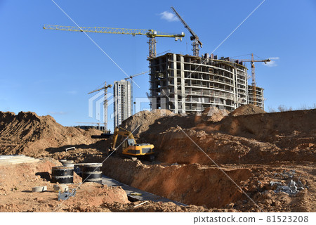 Laying heating pipes in trench at construction site.  81523208