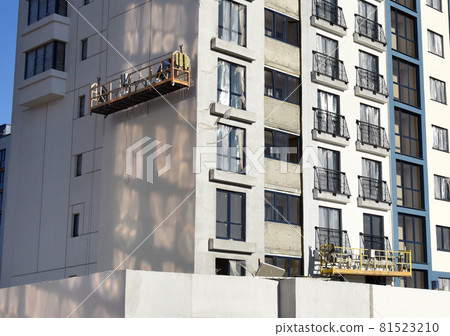 Suspended construction cradle on the background facade of the building.  81523210
