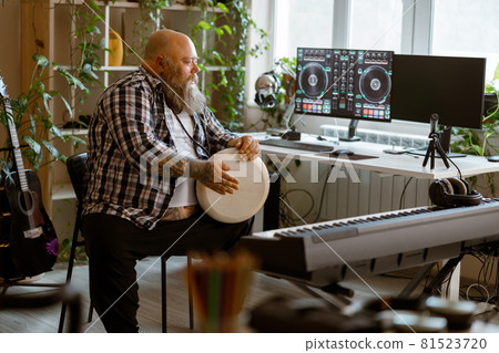 Positine obese man plays drum sitting in home audio record studio 81523720