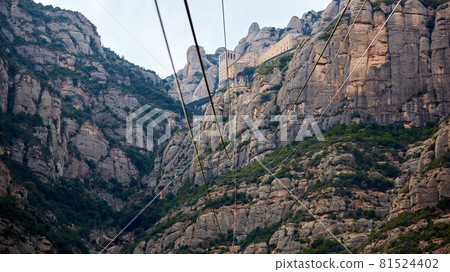 Yellow cable car in the Aeri de Montserrat rise to de Montserrat Abbey near Barcelona, Spain, Catalonia. 81524402