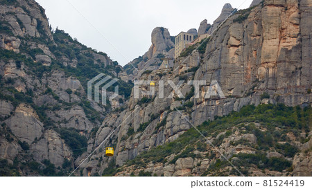 Yellow cable car in the Aeri de Montserrat rise to de Montserrat Abbey near Barcelona, Spain, Catalonia. 81524419