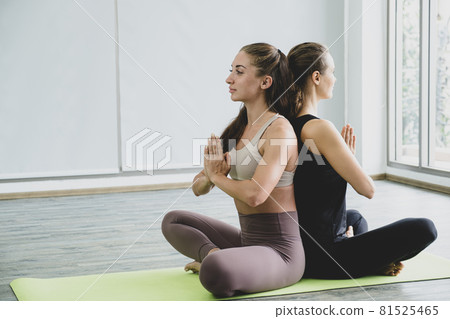 Two Caucasian women exercise doing the yoga pose stretching at home, healthy lifestyle concept Two Caucasian women exercise doing the yoga pose stretching at home, healthy lifestyle concept 81525465