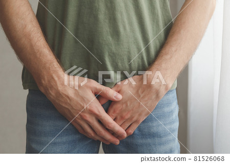 Man cover his groin by hands. Men's health. Urology problems male 81526068