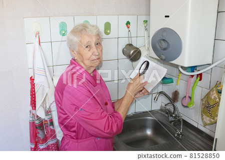 The senior woman at home and examines gas bill 81528850