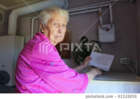 The senior woman at home and examines gas bill 81528858