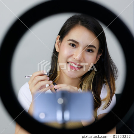 Asian woman are broadcasting live on smartphones, lights, rings, and cosmetics in online sales, shopping in the room at home. Concept online shopping Sell. 81533232