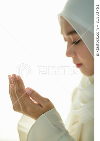 Young and beautiful Asian Muslim woman rise hands and praying with respect and calm manner Young and beautiful Asian Muslim woman rise hands and praying with respect and calm manner 81533761