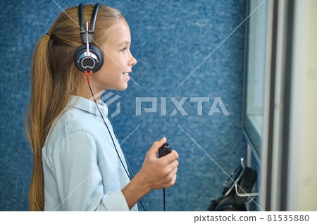 Smiling girl in headphones in the audiometric room 81535880