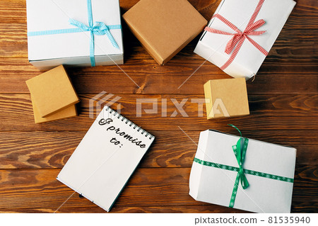 Top view of notebook and gift boxes on wooden table. 81535940