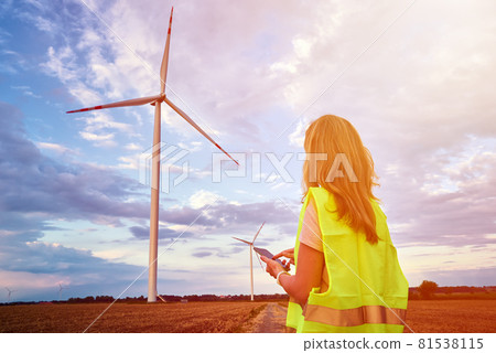 Engineer looks at wind turbine in the field Engineer looks at wind turbine in the field 81538115