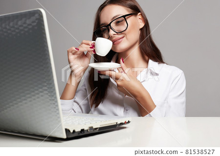 Young Happy business woman drinking coffee. Beautiful girl in glasses Young Happy business woman drinking coffee. Beautiful girl in glasses 81538527