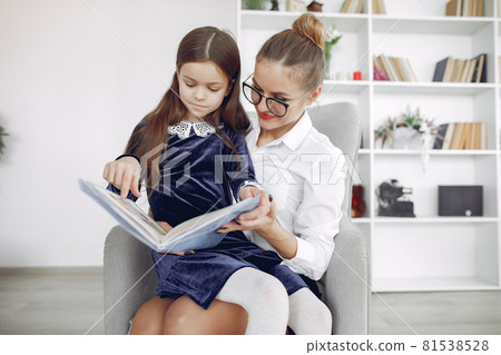 Tutor with litthe girl studying at home Tutor with litthe girl studying at home 81538528