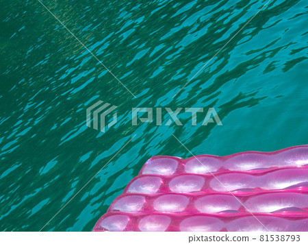 detail of a pink inflatable pad  (mattress)  on  turquoise water 81538793