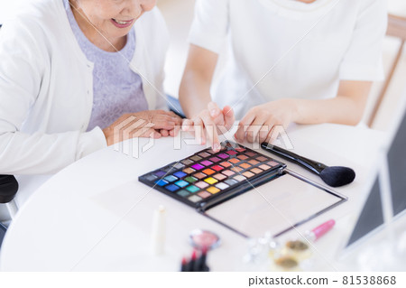 Long-term care make-up therapy Senior woman (at hand) receiving make-up Long-term care make-up therapy Senior woman (at hand) receiving make-up 81538868
