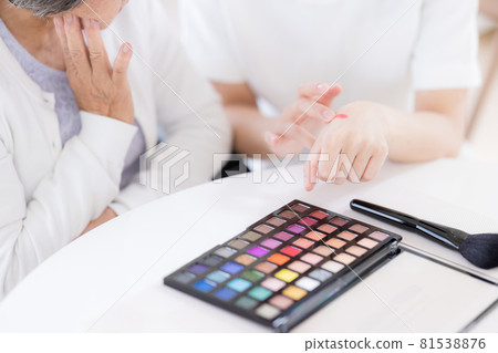 Long-term care make-up therapy Senior woman (at hand) receiving make-up Long-term care make-up therapy Senior woman (at hand) receiving make-up 81538876