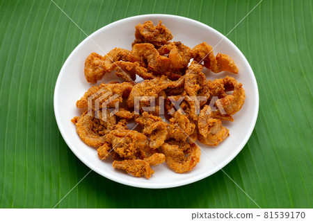 Fried crispy pork belly recipe in white plate on banana leaf 81539170