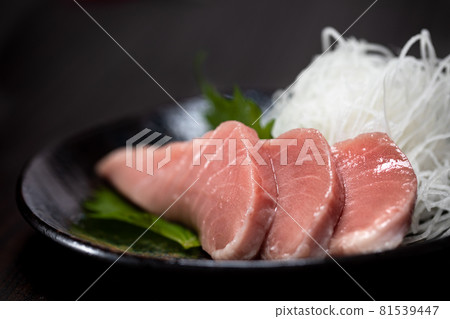 Close-up of tuna sashimi served on a black plate with perilla and perilla 81539447