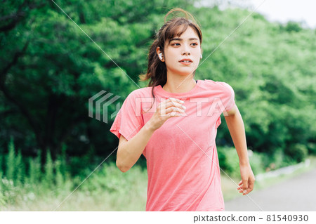 一個女人一邊聽音樂一邊慢跑 81540930