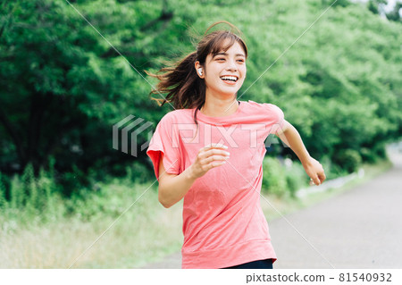 A woman jogging while listening to music A woman jogging while listening to music 81540932
