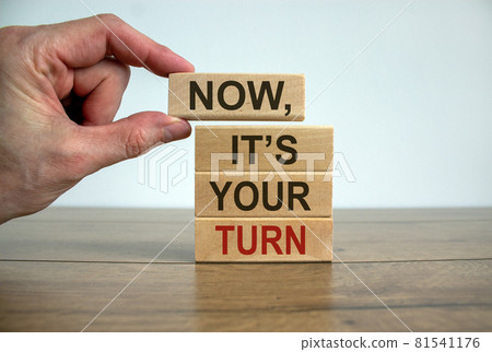Wooden blocks form the words 'now, it's your turn' on beautiful wooden table. White background. Male hand. Business concept. 81541176