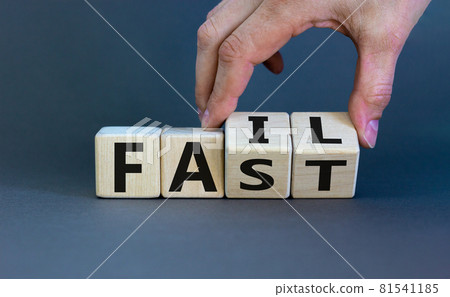 Business and design concept. Man hand flips wooden cubes with words 'fail fast' concept on beautiful grey background, copy space. Business and design concept. Man hand flips wooden cubes with words 'fail fast' concept on beautiful grey background, copy space. 81541185