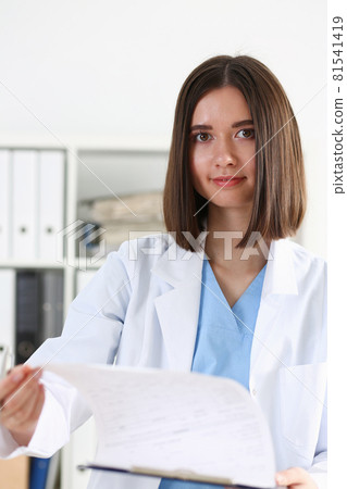 Beautiful smiling female doctor hold clipboard pad Beautiful smiling female doctor hold clipboard pad 81541419