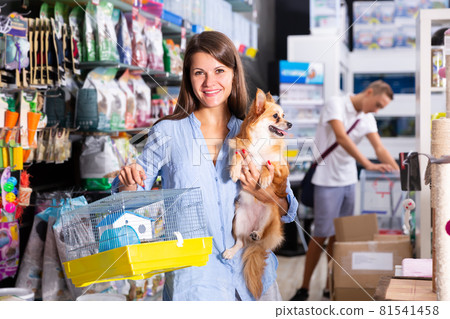 Happy brunette with cute dog choosing cage Happy brunette with cute dog choosing cage 81541458
