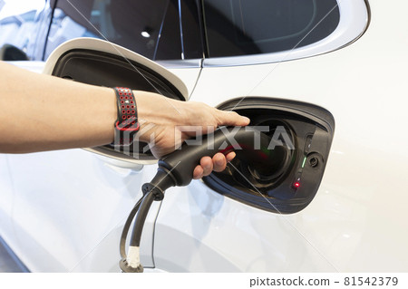 Hand man holding electric car charging in power station. Hand man holding electric car charging in power station. 81542379