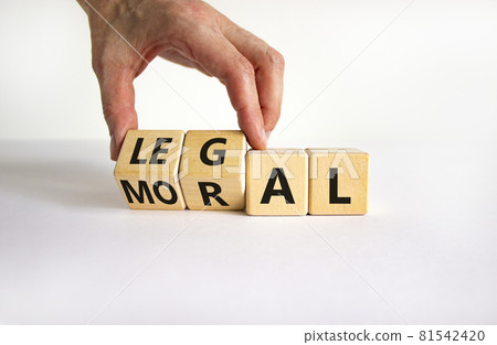 Moral or legal symbol. Businessman turns wooden cubes and changes the word 'moral' to 'legal' on a beautiful white table, white background. Business and moral or legal concept. Copy space. Moral or legal symbol. Businessman turns wooden cubes and changes the word 'moral' to 'legal' on a beautiful white table, white background. Business and moral or legal concept. Copy space. 81542420