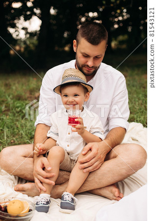 Cheerful boy with his dad drinking juice. Cheerful boy with his dad drinking juice. 81543121