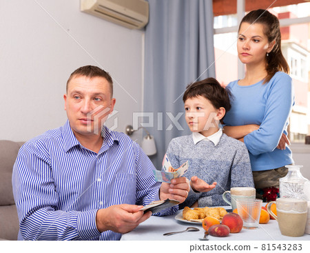 Upset father giving money to wife and son 81543283