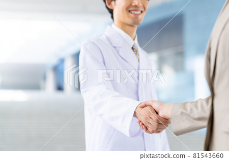 一個穿白大褂的男人和一個年輕的女商人握手 81543660