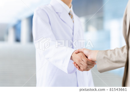 一個穿白大褂的男人和一個年輕的女商人握手 一個穿白大褂的男人和一個年輕的女商人握手 81543661
