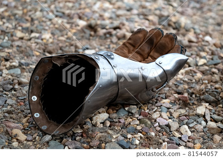 Metallic gauntlet as part of knight equipment abandoned on the ground 81544057