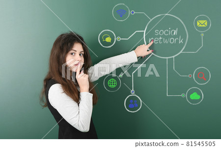 Pre-adolescent girl standing against social network chalk drawing on blackboard 81545505