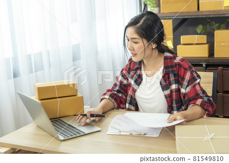 Online seller Close up hands Young asian woman typing laptop keyboard checking online order, check goods stock delivery package shipping postal. Asian woman startup small business at home office 81549810