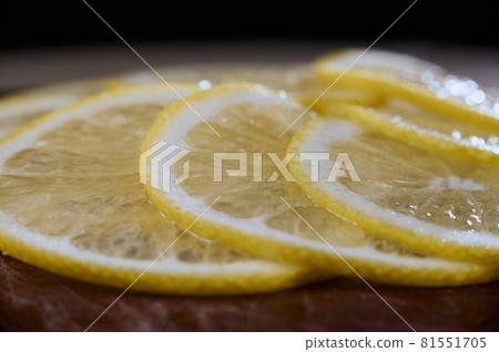 Lemon slices close-up on a dark background. The background is in blur. 81551705