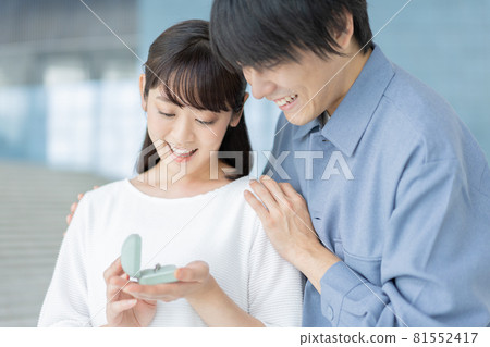 Proposal A young woman smiling with a ring in her hand 81552417