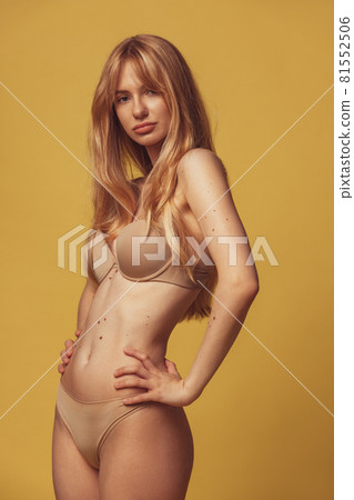 Confident young woman posing in her natural body isolated over brown studio background.. Body positive, treatment, healthcare, diversity concept 81552506