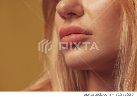 Cropped shot of face of young beautiful woman isolated over colored studio background. Natural beauty, wellness, healthy lifestyle, cosmetics concept. 81552526