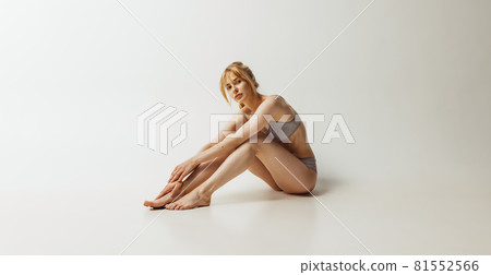 Portrait of young pretty, adorable woman in lingerie isolated over gray studio background. Natural beauty concept. Authenticity 81552566