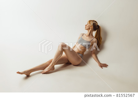 Portrait of young pretty, adorable woman in lingerie isolated over gray studio background. Natural beauty concept. Authenticity 81552567