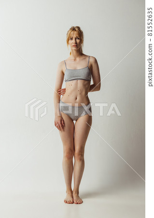Portrait of young adorable woman in lingerie isolated over gray studio background. Natural beauty concept. Authenticity, natural beauty Portrait of young adorable woman in lingerie isolated over gray studio background. Natural beauty concept. Authenticity, natural beauty 81552635
