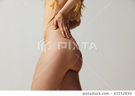 Back view of young beautiful slim tanned woman in lingerie posing isolated over light studio background. Natural beauty, wellness, healthy lifestyle concept. Back view of young beautiful slim tanned woman in lingerie posing isolated over light studio background. Natural beauty, wellness, healthy lifestyle concept. 81552656