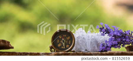 Mountain route planning - compass, binoculars, quartz crystals, slate and lavender flowers 81552659
