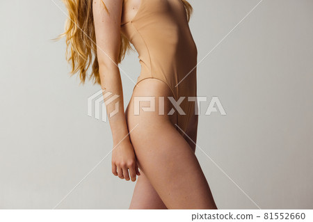 Side view of slender female legs with well-kept skin and some birthmarks isolated over light studio background. Natural beauty, wellness, healthy lifestyle concept. 81552660