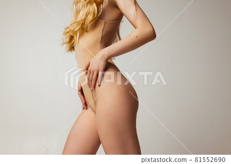 Side view of slender female legs with well-kept skin and some birthmarks isolated over light studio background. Natural beauty, wellness, healthy lifestyle concept. Side view of slender female legs with well-kept skin and some birthmarks isolated over light studio background. Natural beauty, wellness, healthy lifestyle concept. 81552690